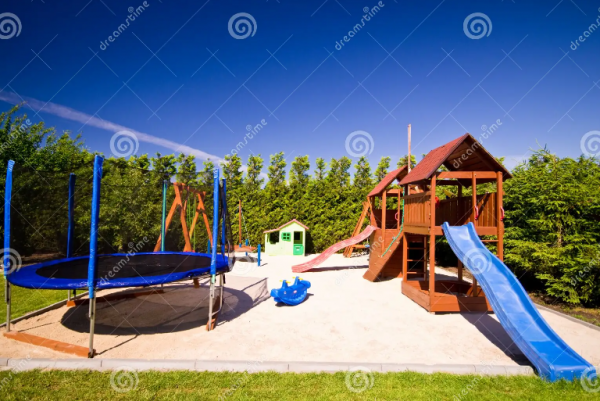 Taman dengan area bermain anak yang dilengkapi dengan trampolin dan ayunan